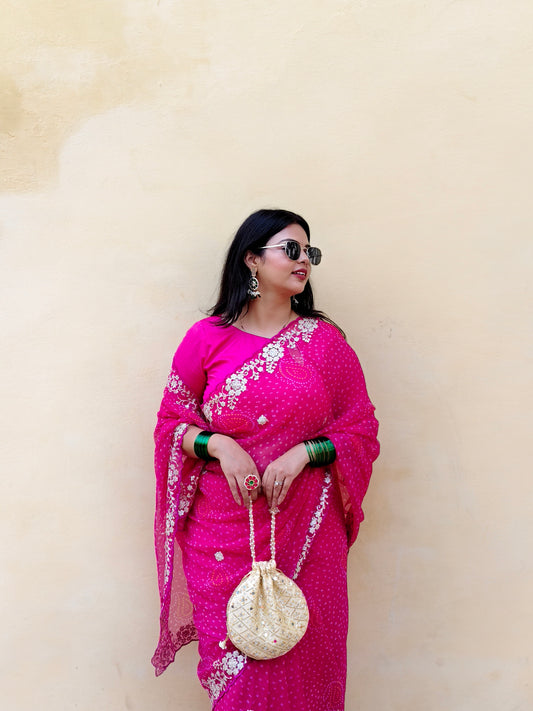 Woman in a bright pink chiffon bandhani saree.