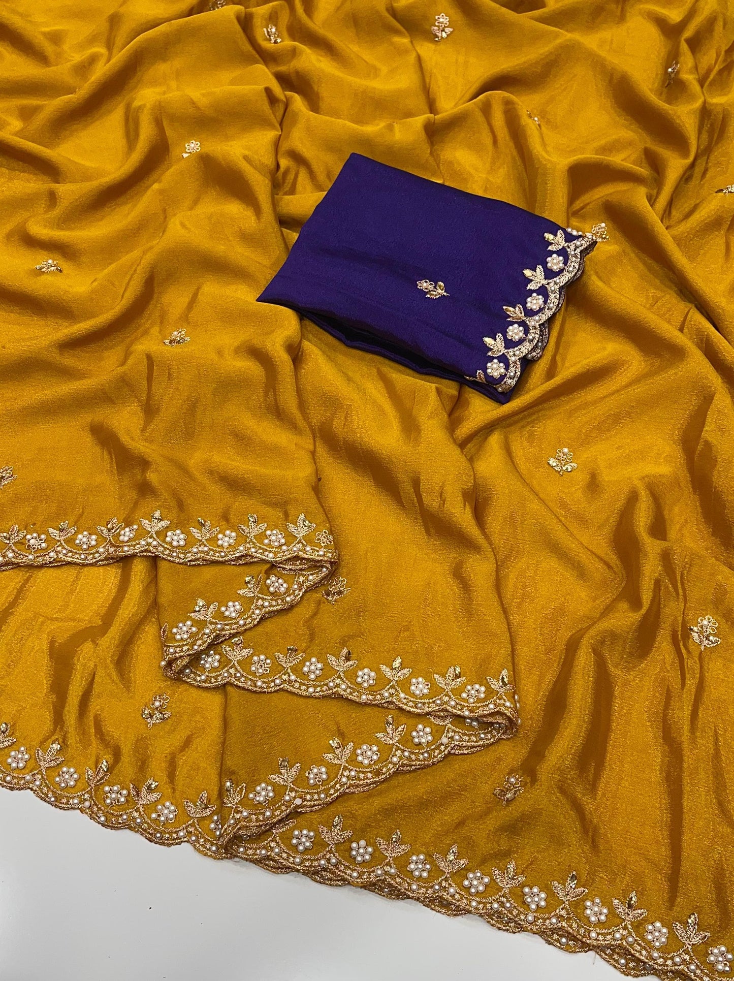 Mustard yellow chinon saree with intricate embroidery and a purple blouse piece