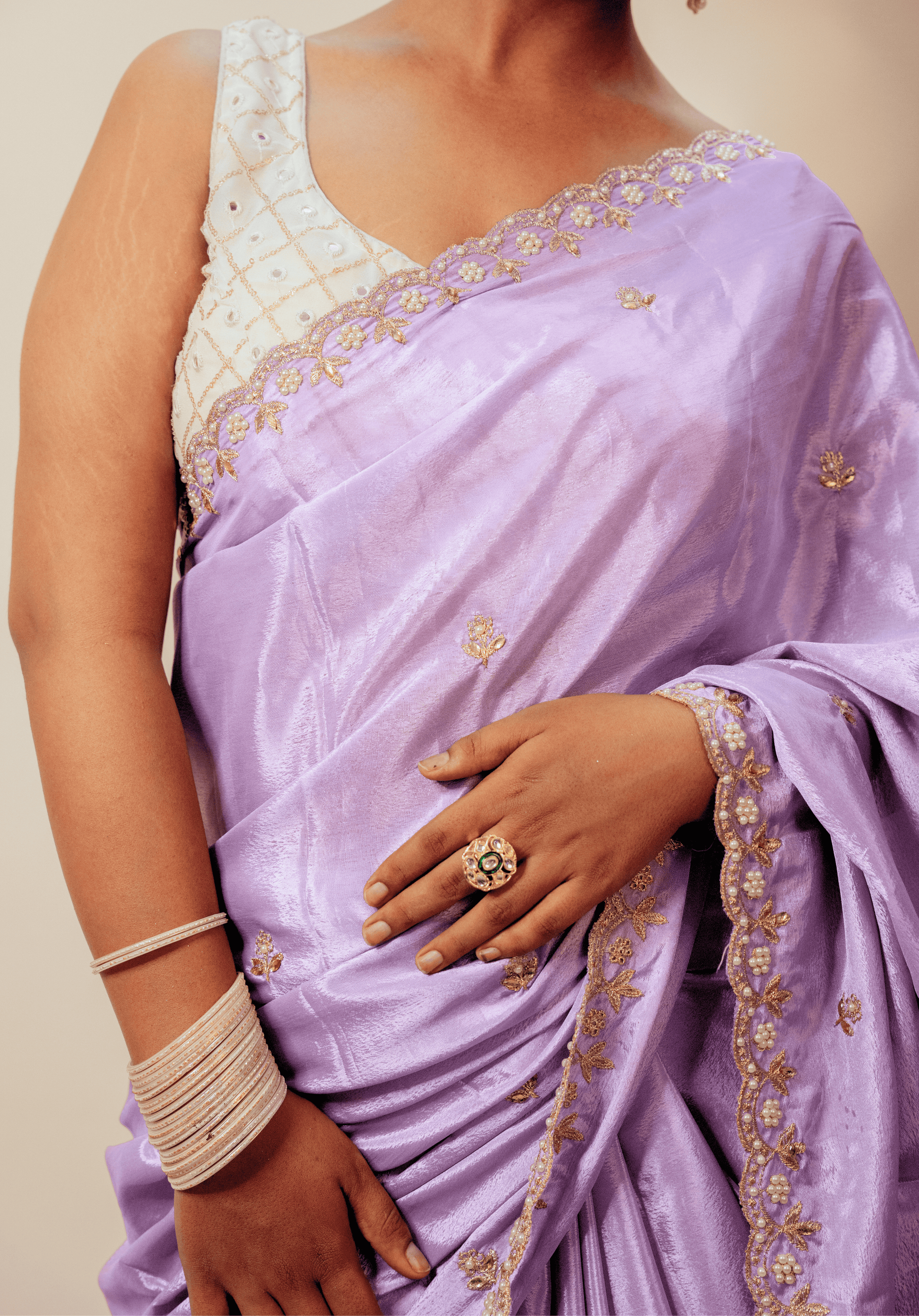 Close up detailing of  lilac chinon saree with gold and white embroidery 