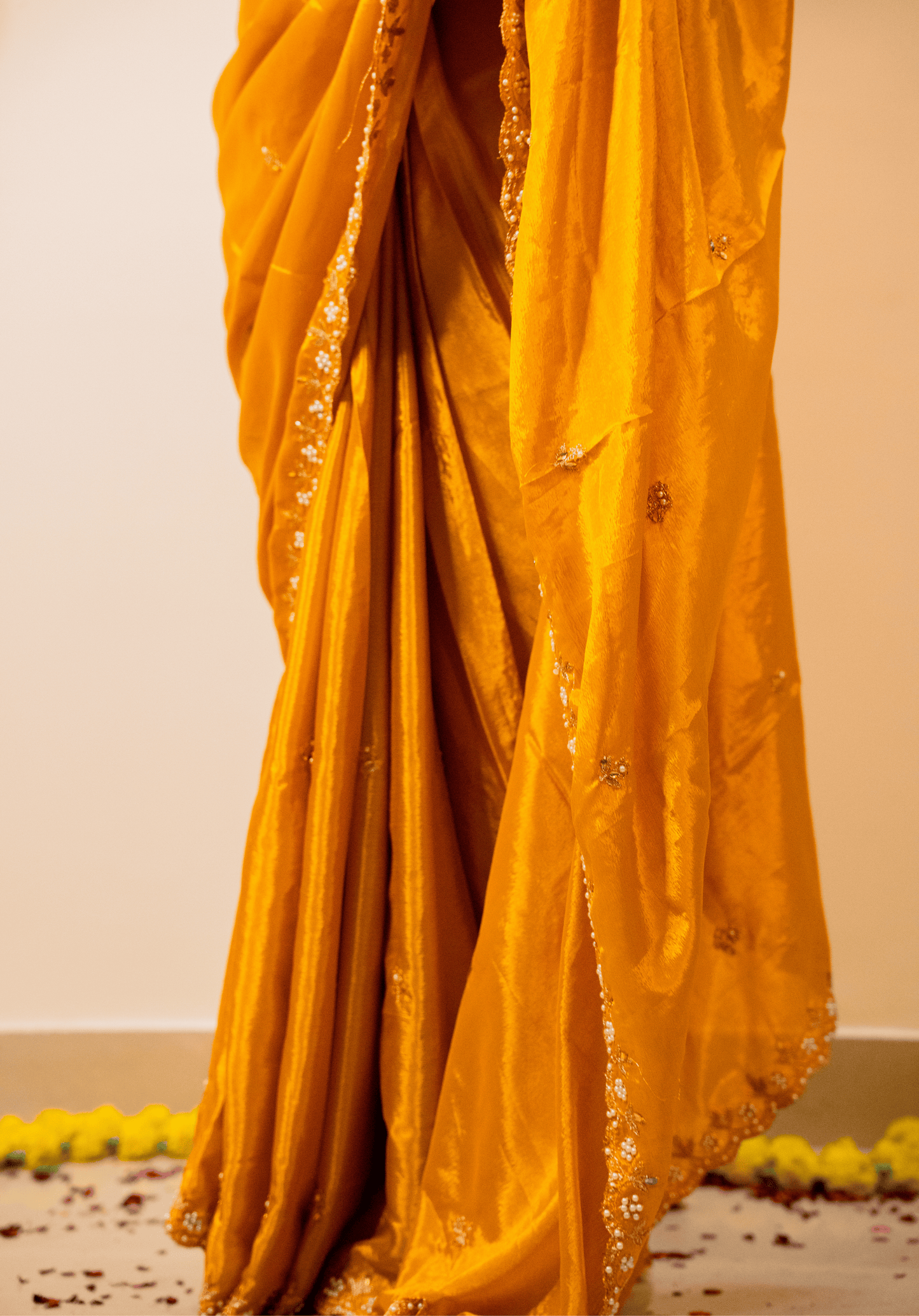 close up of yellow chinon saree with intricate embroidery.