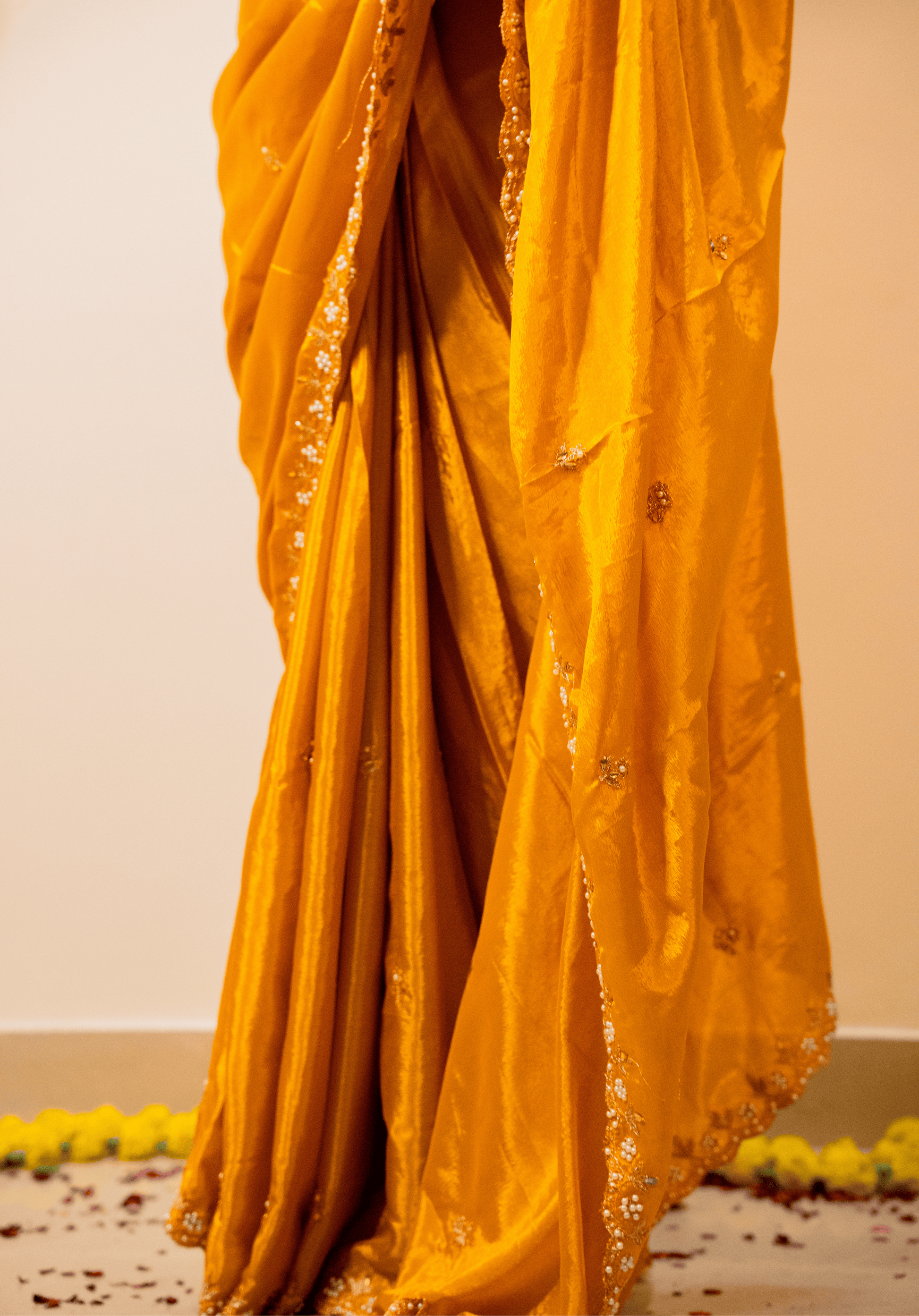 close up of yellow chinon saree with intricate embroidery.