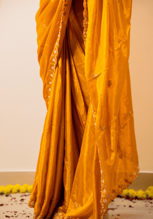 close up of yellow chinon saree with intricate embroidery.