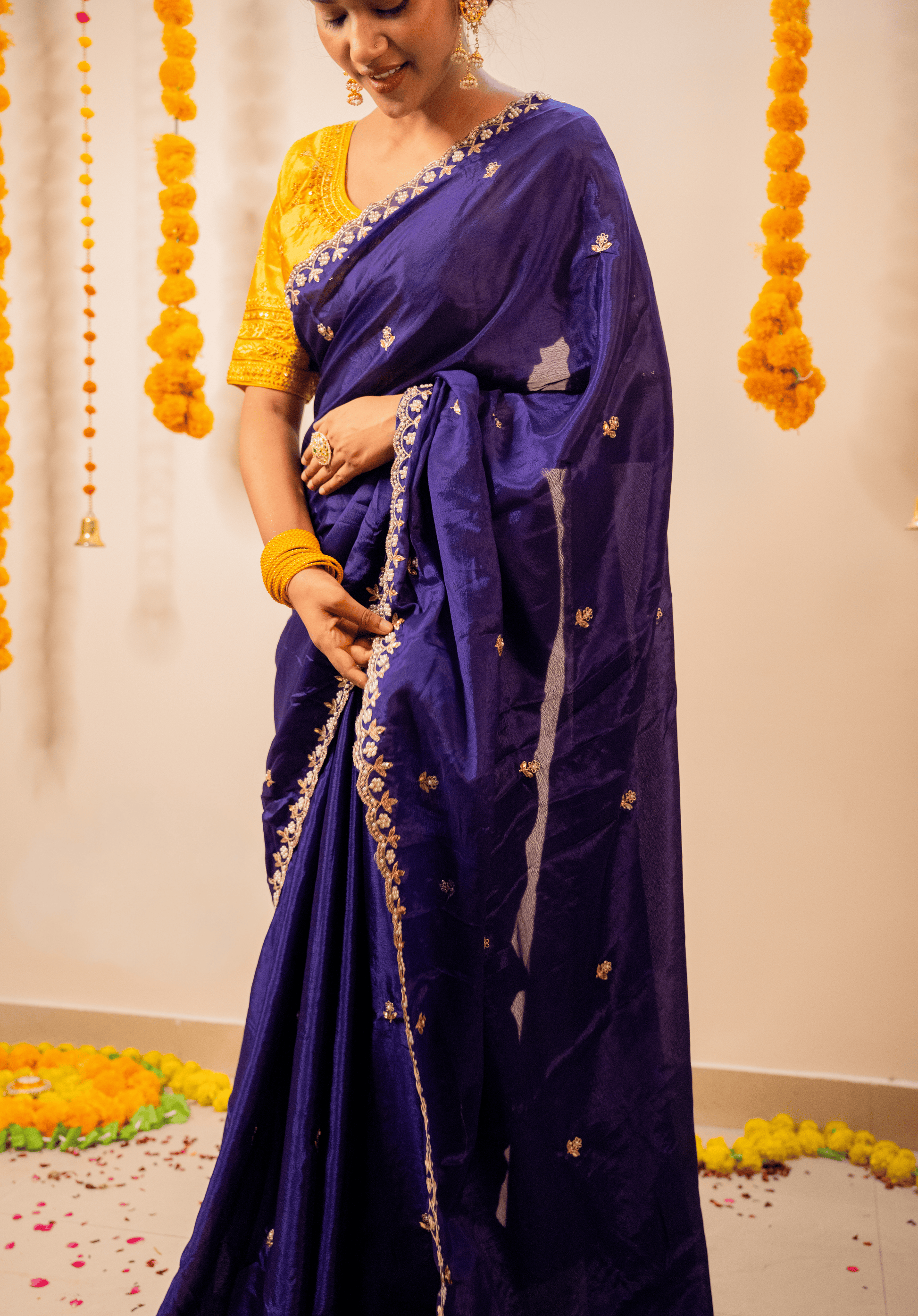 Women wearing a purple chinon saree with gold border 