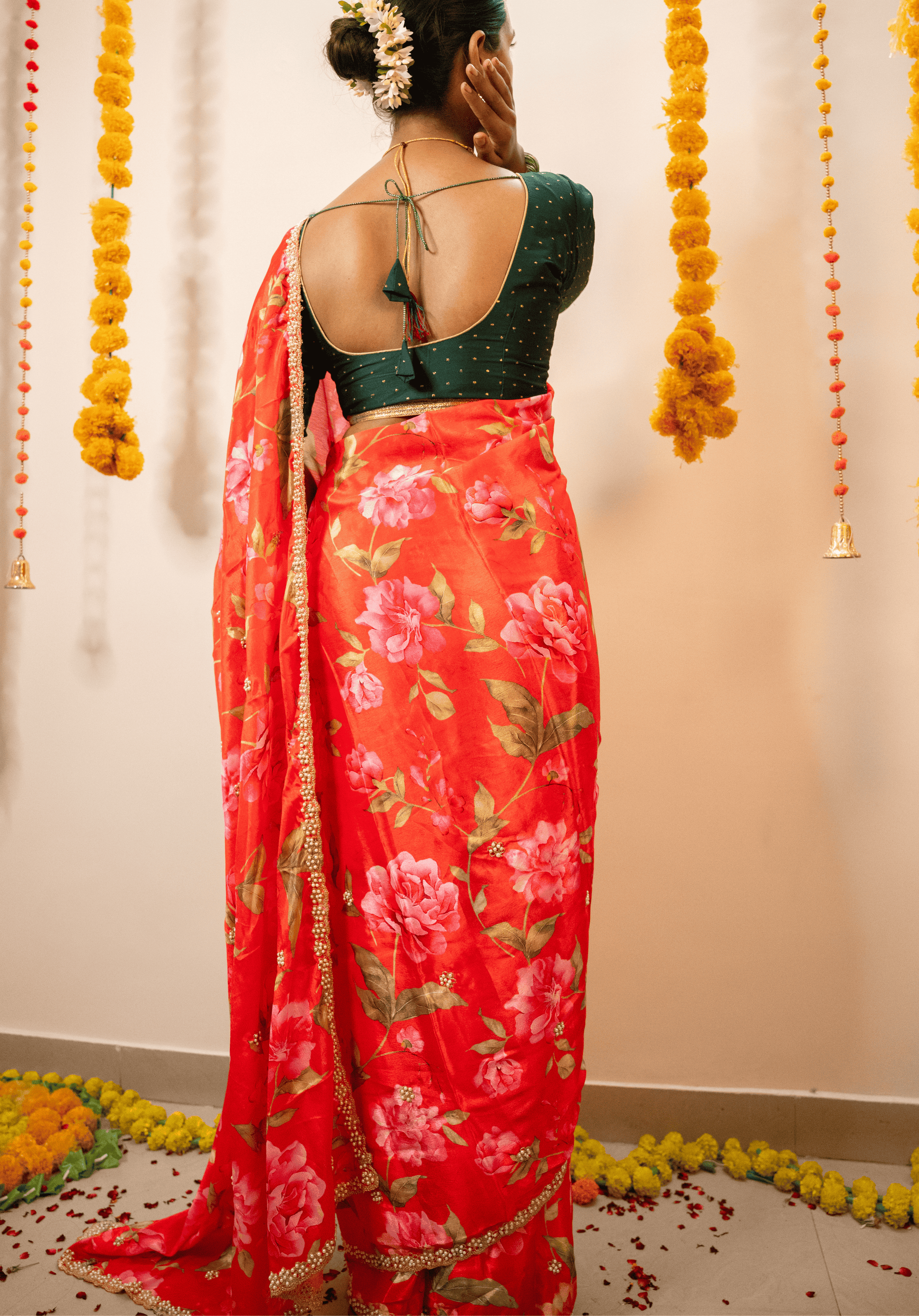 Person wearing a cherry red floral chinon saree with a green blouse.