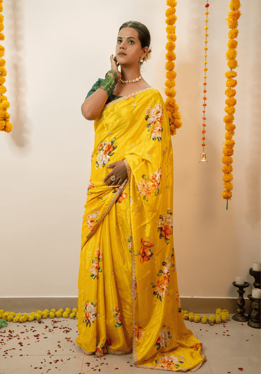 Woman in a lemon yellow chinon saree with floral patterns and embroidered border.
