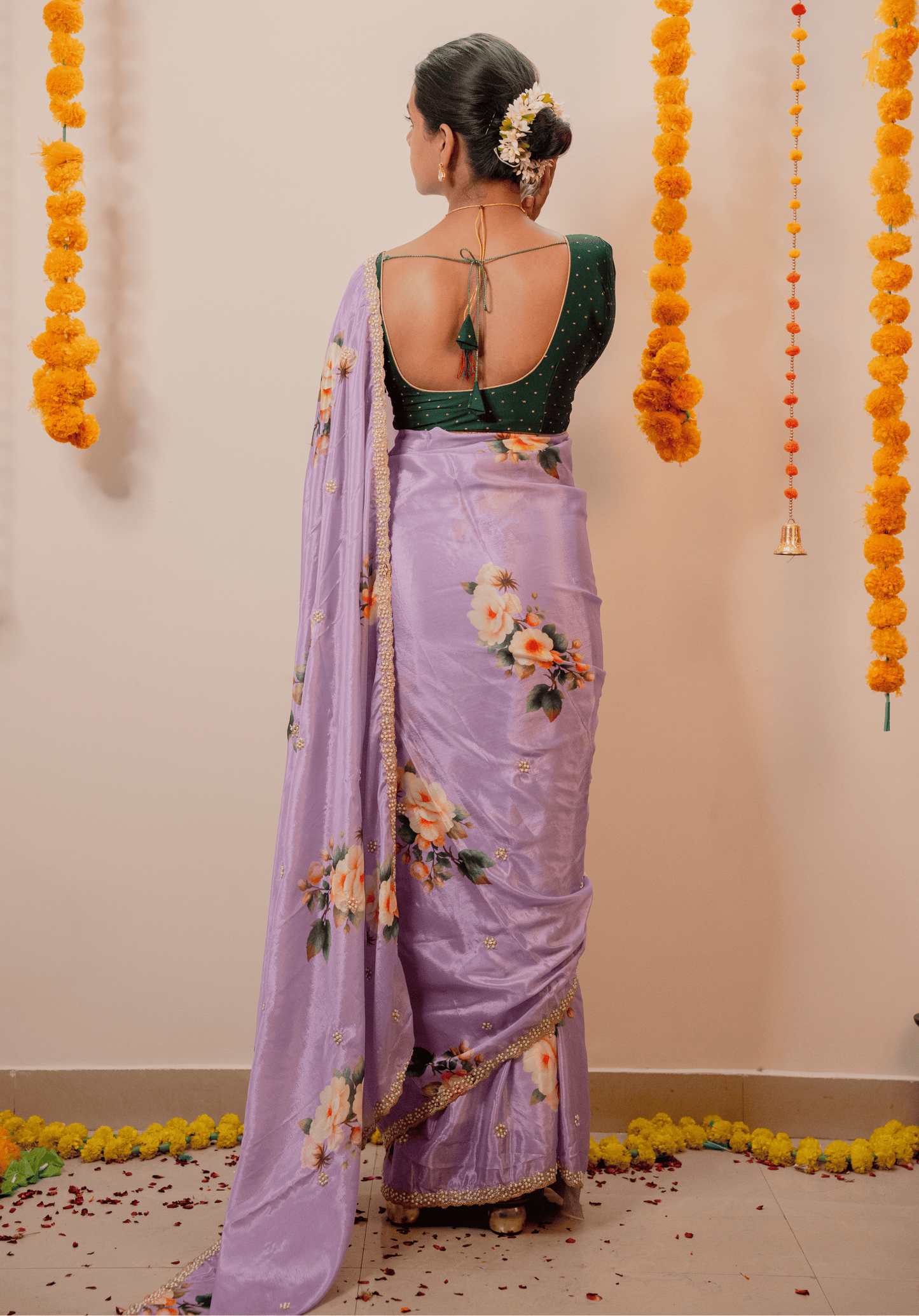 Woman in a lilac chinon saree with floral patterns and embroidered border.