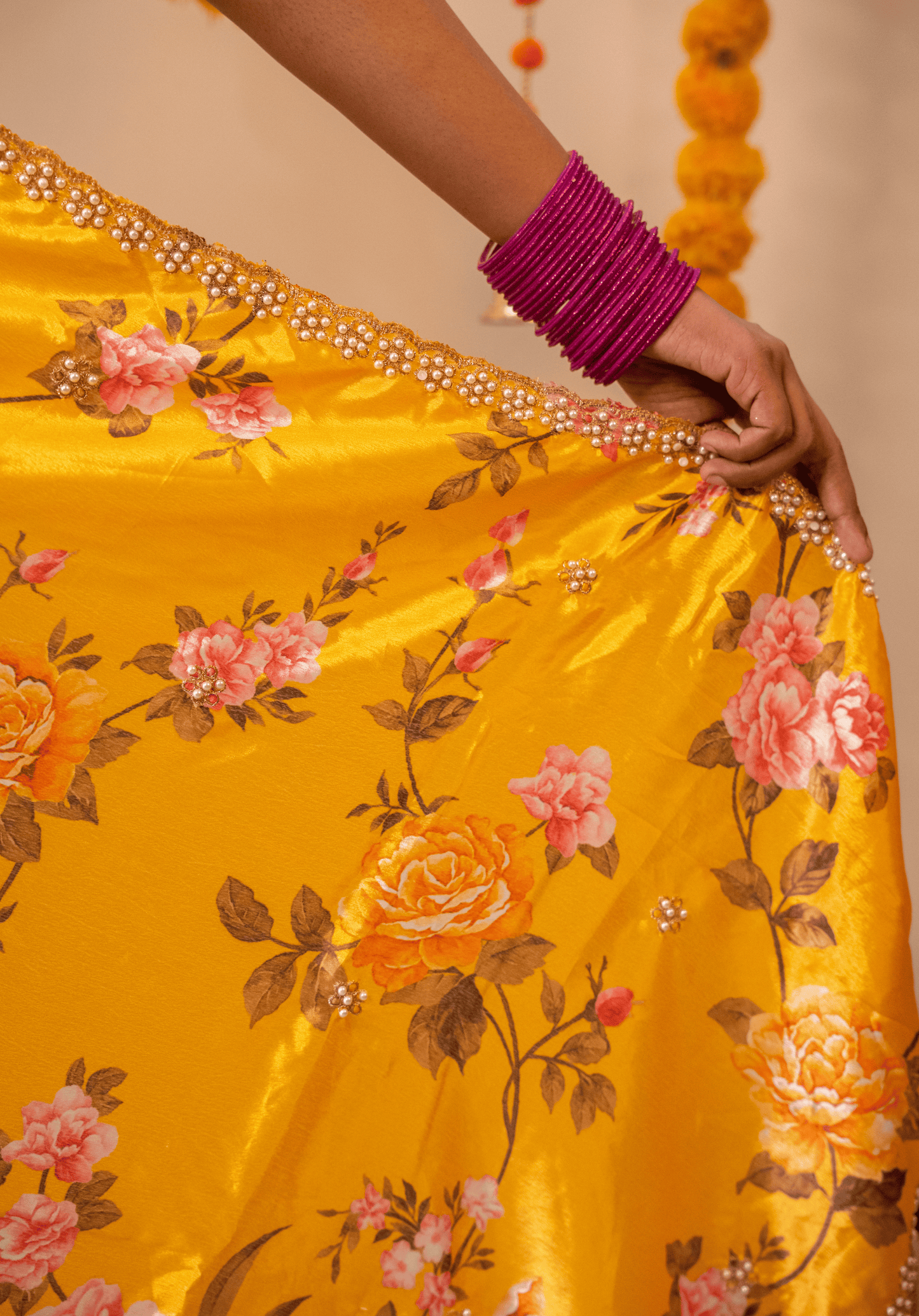 Close up detailing of mustard yellow floral chinon saree with gold and white embroidery.