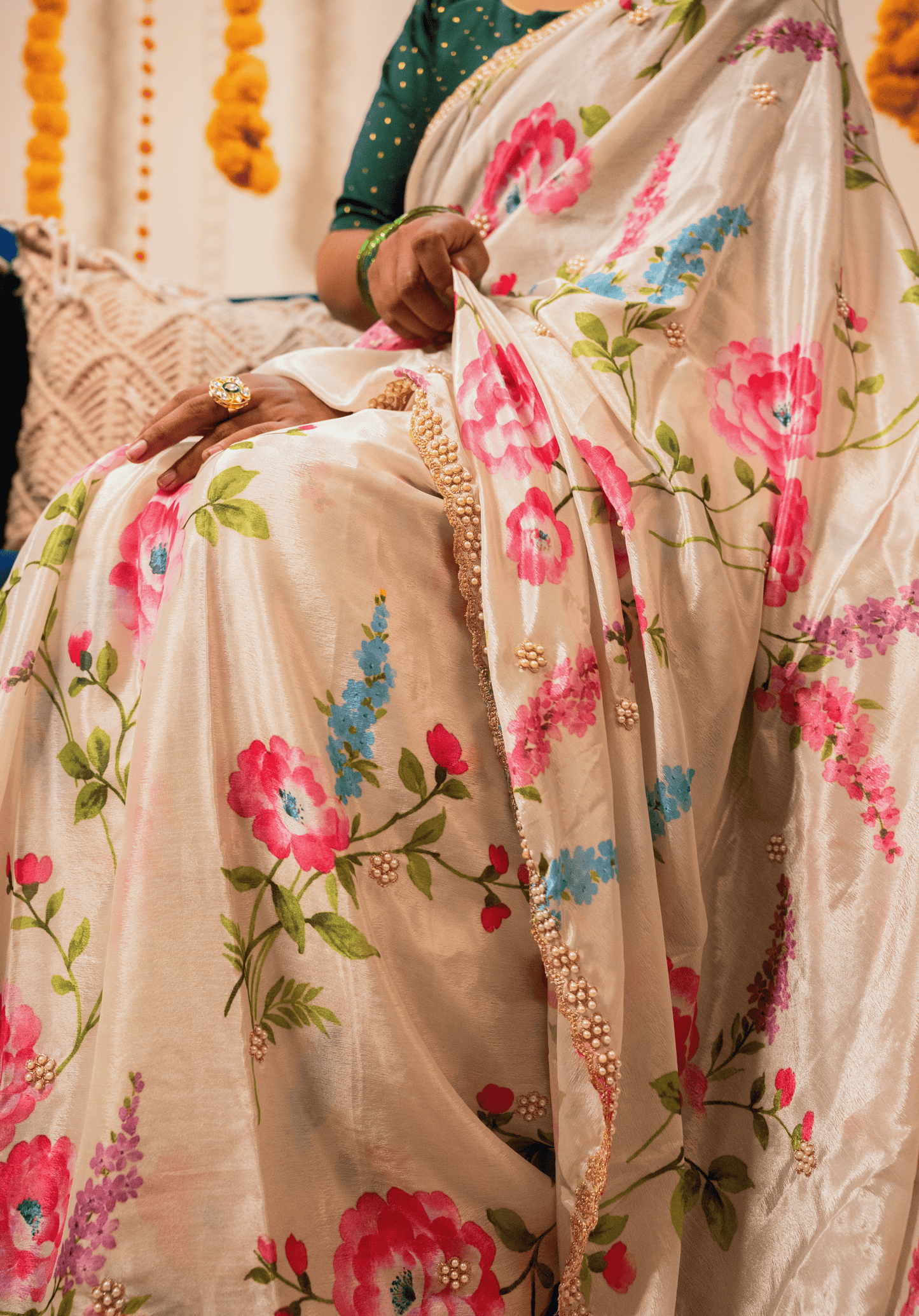 Off white floral saree with floral patterns and embroidered border worn by a person