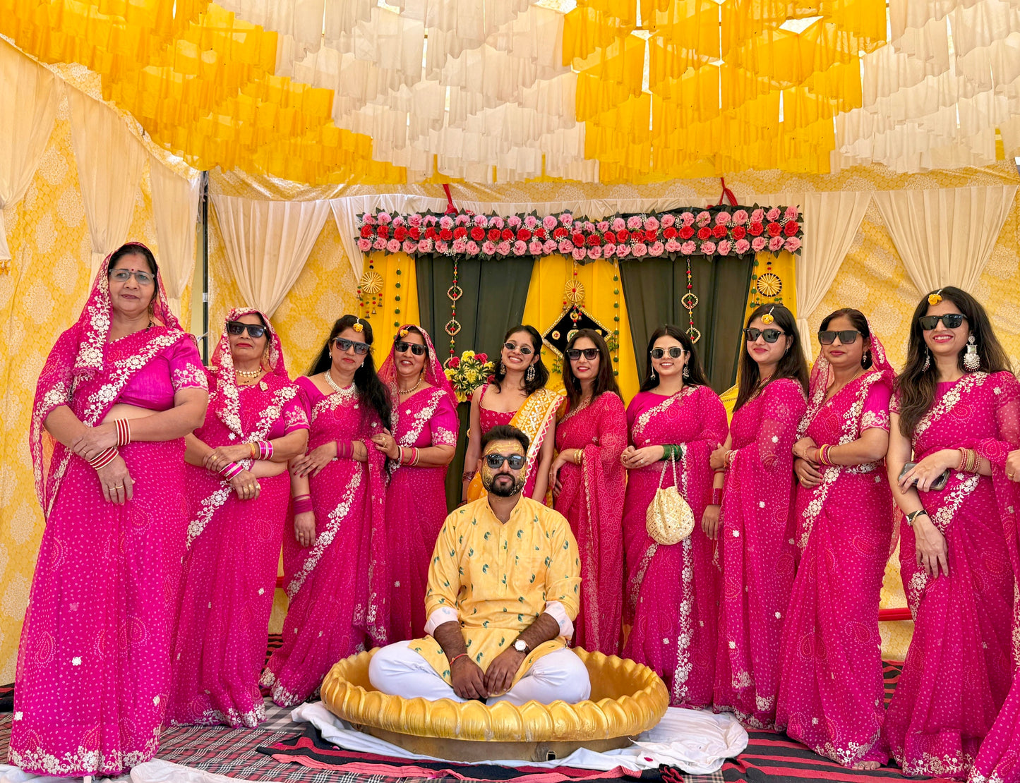 Women wearing pink chiffon bandhani saree for haldi function.