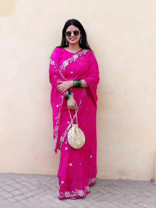 Woman wearing a bright pink pure chiffon bandhani saree for festivities.